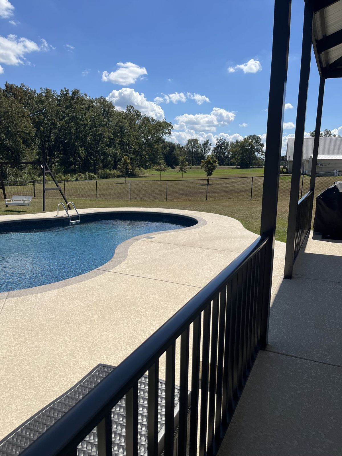 Pool and coated deck seen from the porch railing