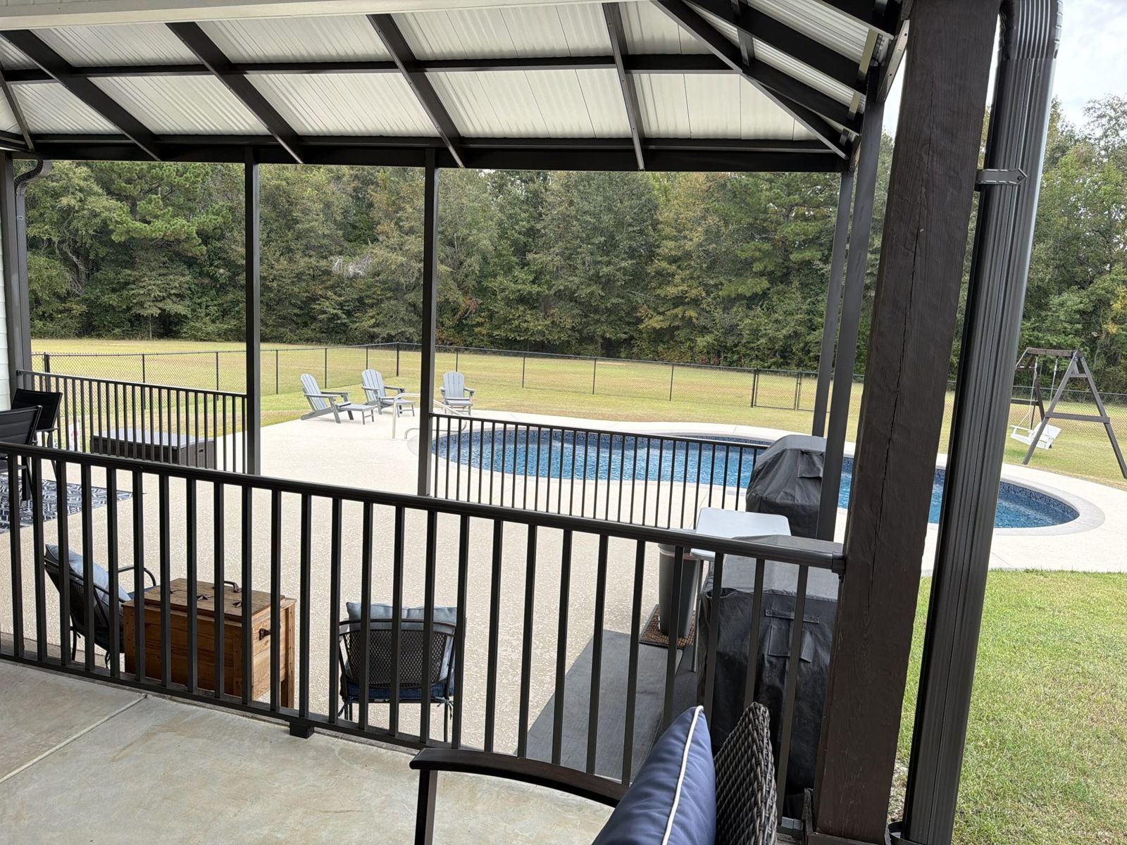 Pool and fenced yard from under the patio cover
